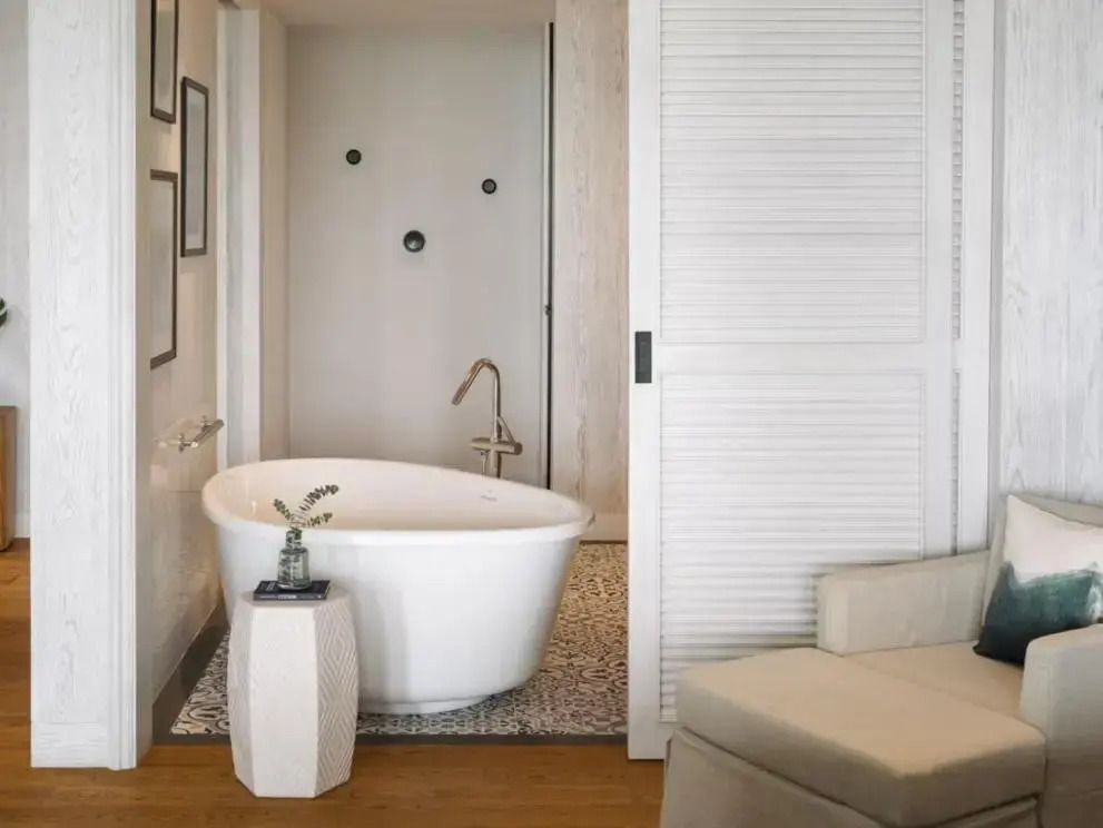 Modernes Badezimmer der Suite mit freistehender Badewanne und stilvollem Design.