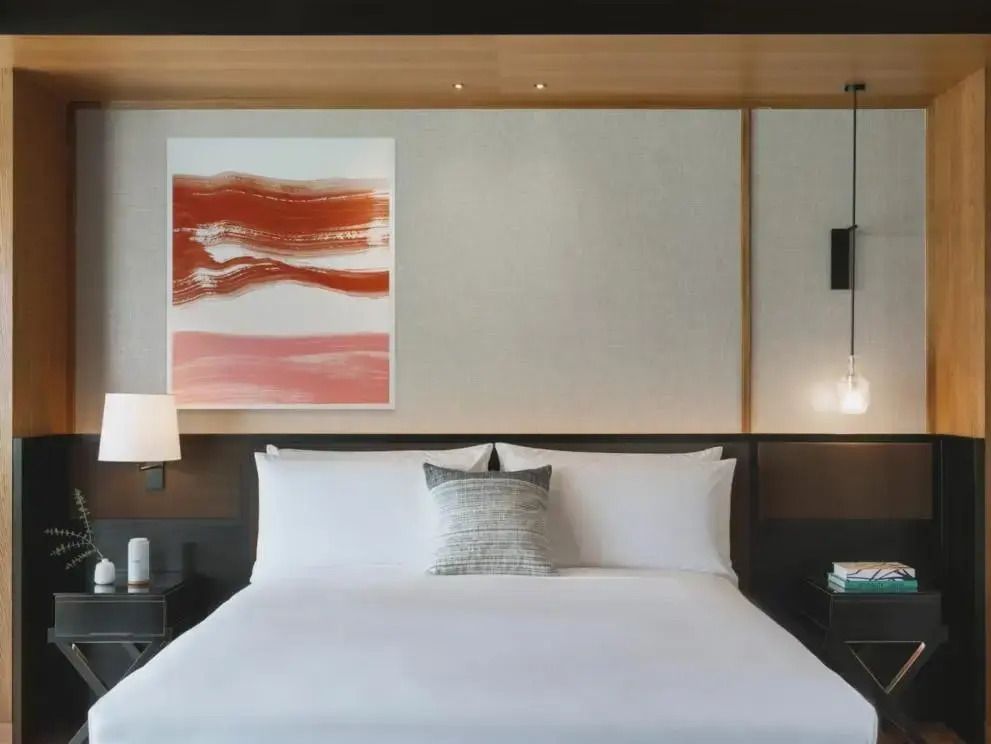 Modernes Schlafzimmer mit Doppelbett, stilvolle Wanddekoration und dezente Beleuchtung