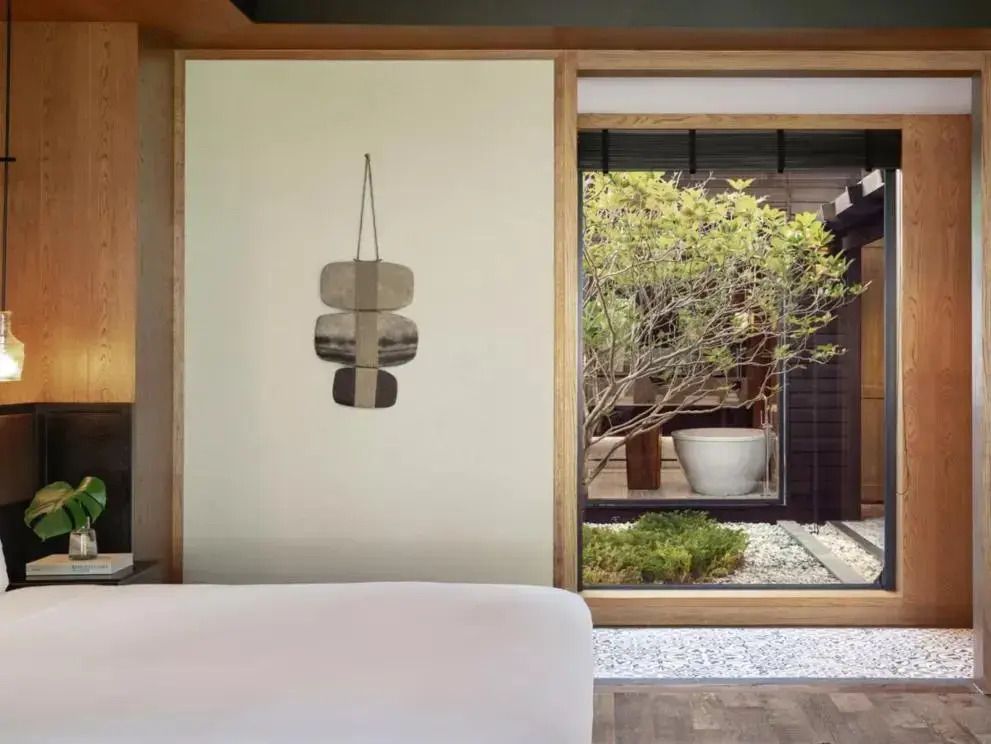 Großes Schlafzimmerfenster mit Blick auf gepflegten Garten mit Bonsai und Kieselsteinen