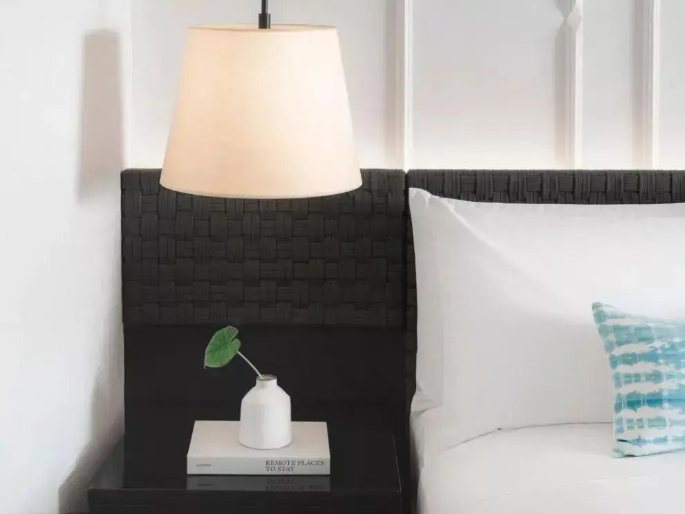 Detailaufnahme eines Nachttisches mit Lampe und Buch