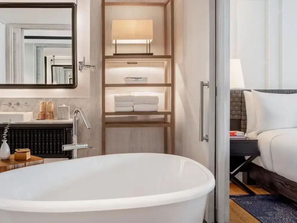 Moderne Badewanne im eleganten Badezimmer mit Regalen