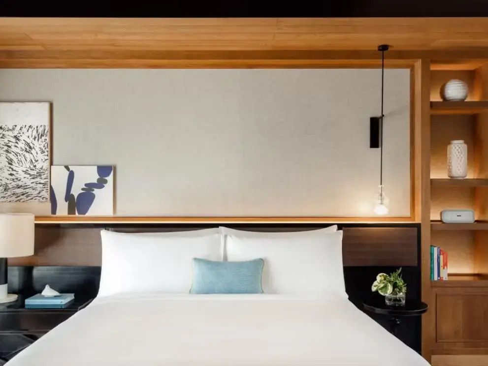 Modernes Schlafzimmer mit stilvoller Wandkunst und luxuriösem Doppelbett.