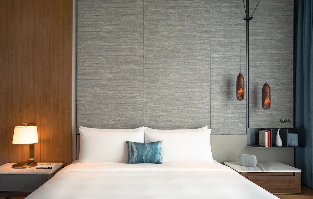 Gepflegtes Bett mit weißen Kissen in modernem Zimmerdesign
