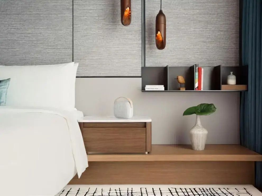 Bequemes Doppelbett mit modernem Nachttisch und stilvoller Beleuchtung