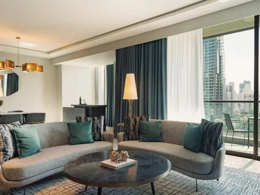 Großer Wohnbereich mit grauen Sofas und bodentiefen Fenstern mit Stadtblick