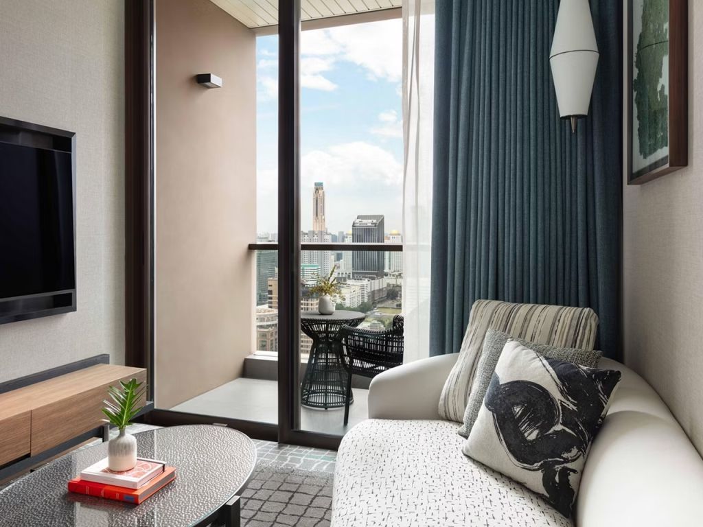 Gemütlicher Wohnbereich mit Zugang zu einem Balkon und beeindruckendem Stadtpanorama.