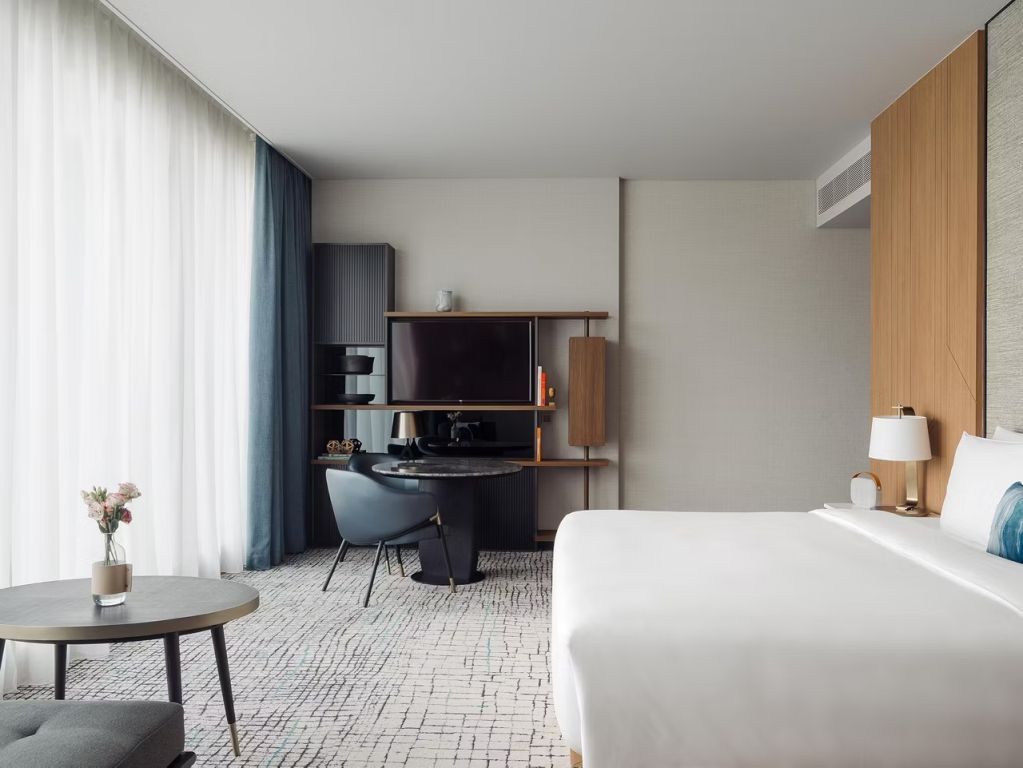 Stilvolles Hotelzimmer mit Doppelbett und modernem Schreibtisch bei Kimpton Maa-Lai Bangkok