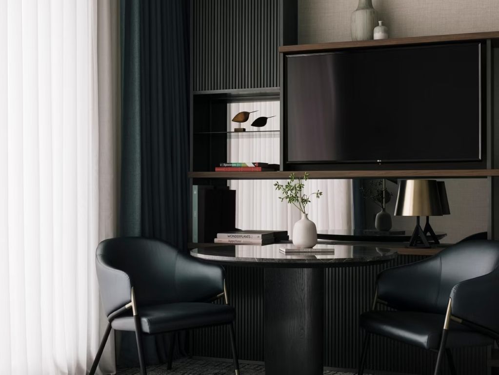 Moderner Schreibtischbereich im Hotelzimmer mit zwei Stühlen und Regalen