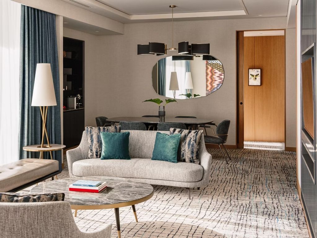 Luxuriöses Wohnzimmer mit Sofas, Spiegel und eleganter Dekoration in der Familiensuite.