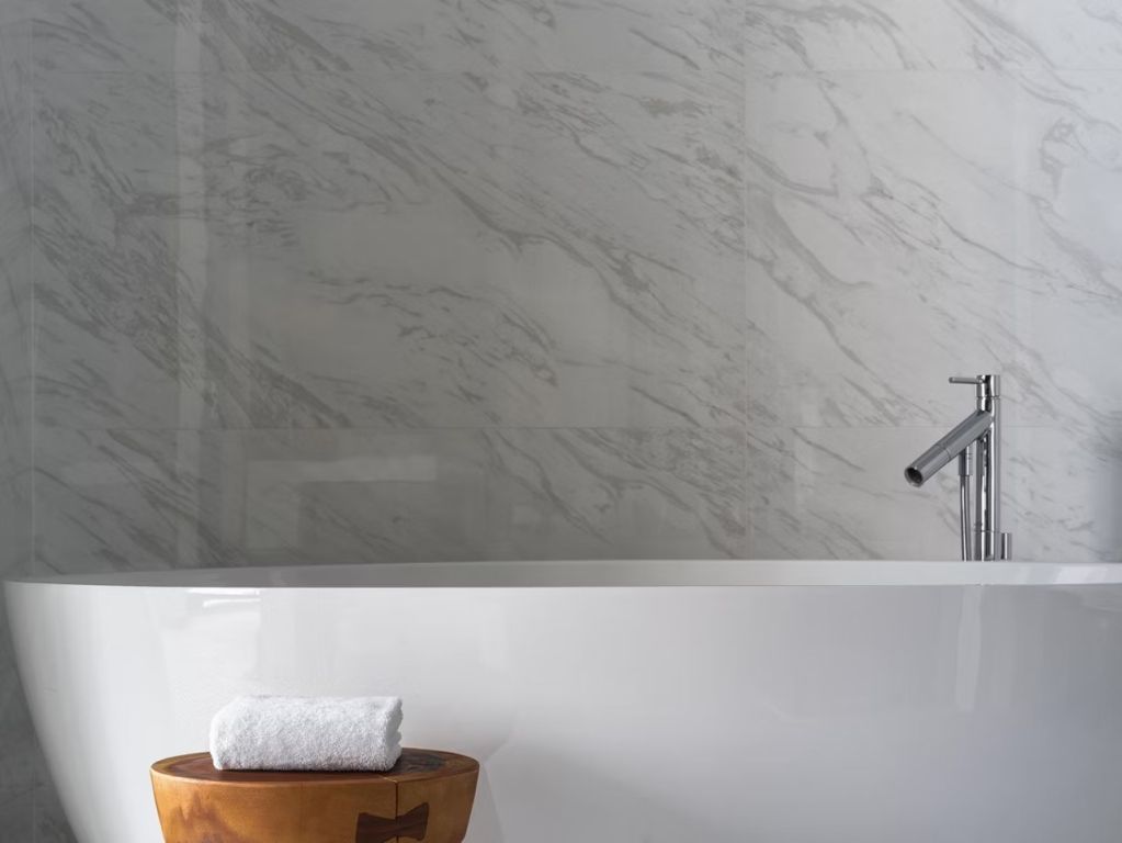 Luxuriöses Badezimmer mit Marmordekor und freistehender Badewanne