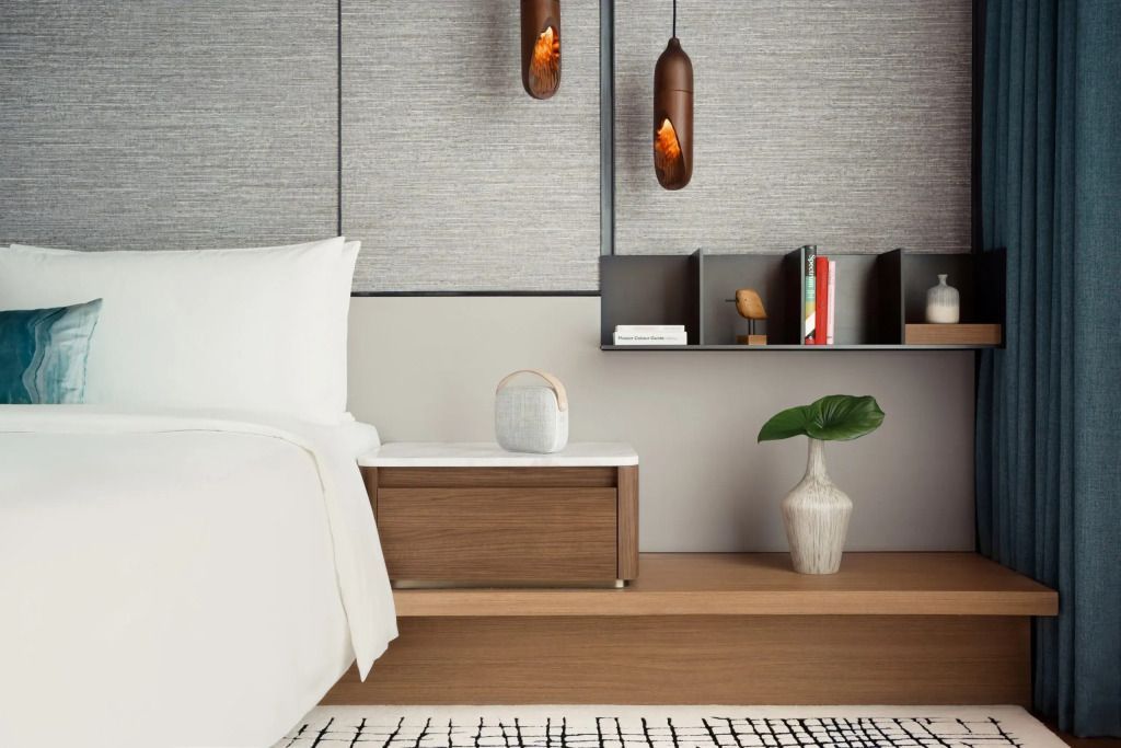 Gemütlicher Schlafbereich mit Designerbeleuchtung und stilvollen Möbeln in der Kimpton Suite