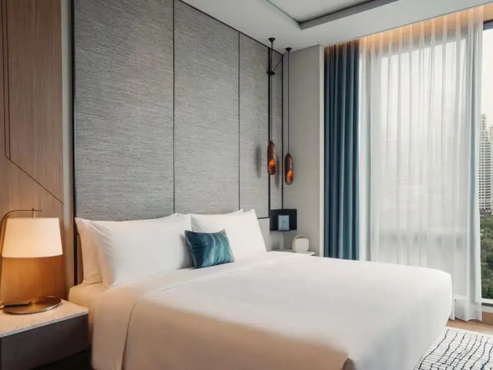 Helles Schlafzimmer mit Doppelbett und großer Fensterfront