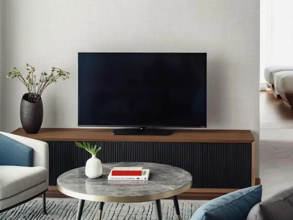 Wohnbereich mit großem Flachbildfernseher und Couchtisch