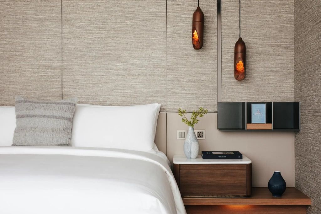 Detailansicht eines eleganten Schlafzimmerteils mit Designer-Pendelleuchten und Couch.