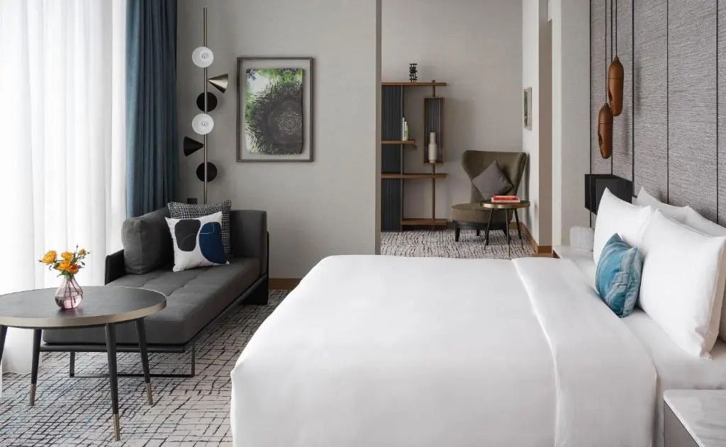 Elegante Suite mit gemütlicher Sitzecke und moderner Kunst an der Wand.