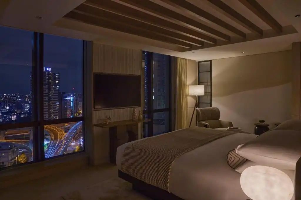 Luxuriöses Schlafzimmer mit Stadtblick bei Nacht und eleganter Beleuchtung