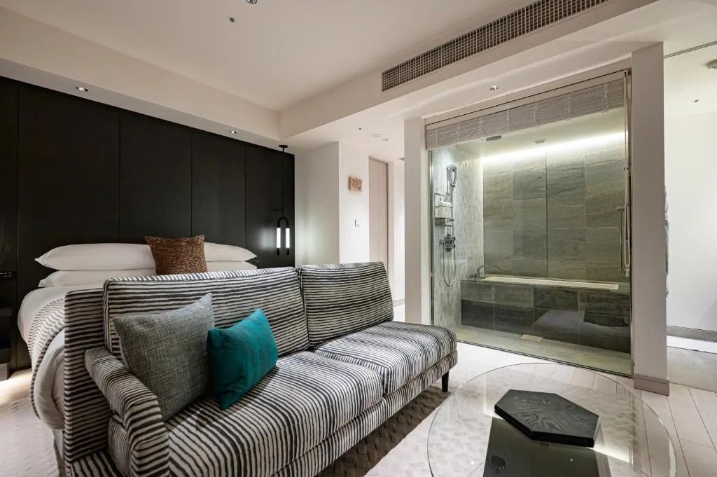 Hotelzimmer mit Sitzbereich und Blick auf ein modernes Badezimmer