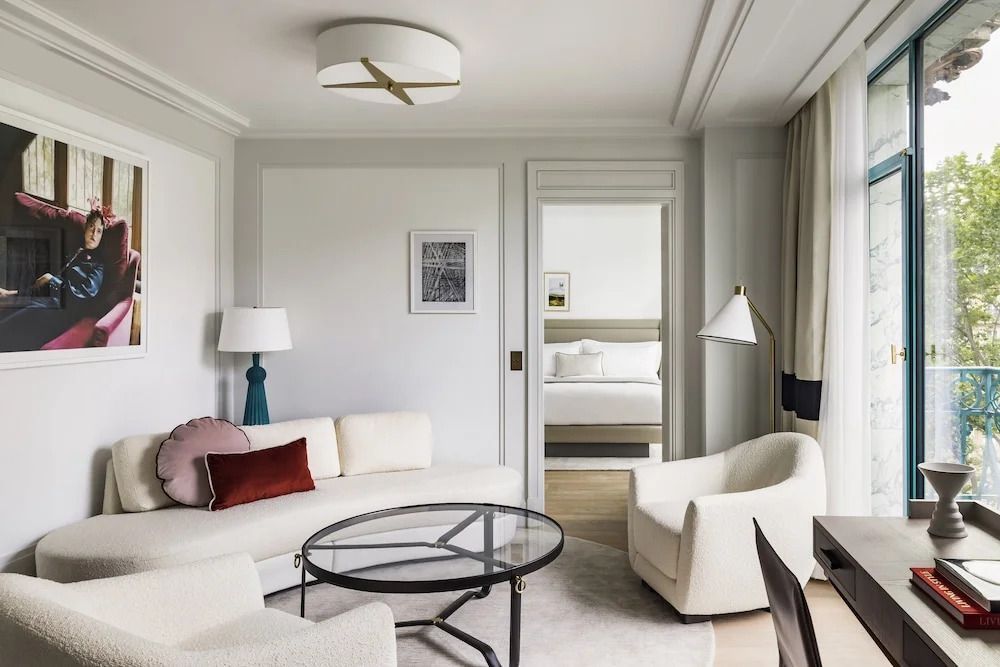 Helles Wohnzimmer einer Suite mit stilvollen Möbeln und Zugang zum Schlafzimmer.