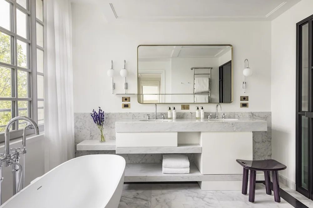 Luxuriöses Badezimmer mit Doppelwaschbecken und Marmorverkleidung.