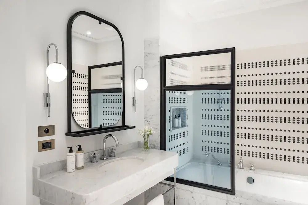 Modernes Badezimmer mit großzügigem Spiegel und eleganter Ausstattung.