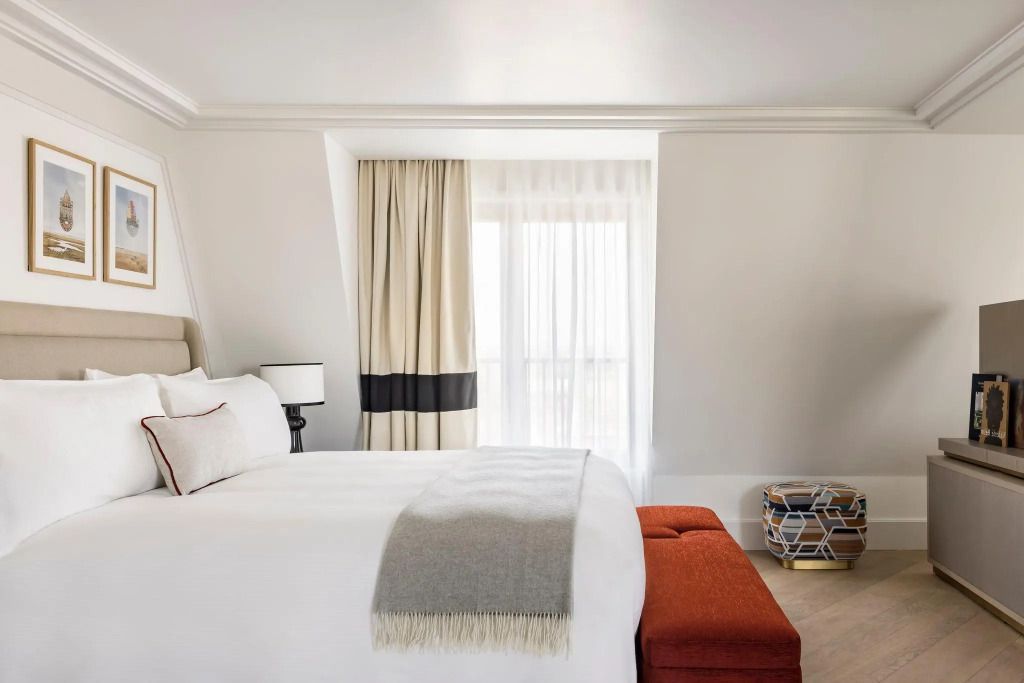 Modernes Zimmer mit komfortablem Bett und Hocker