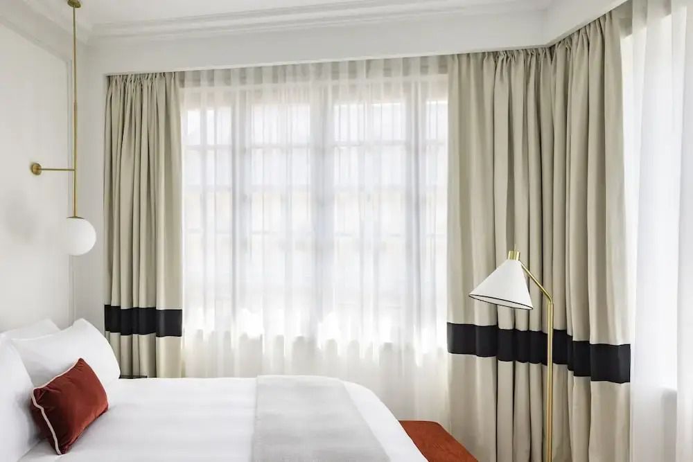 Helles Zimmer mit großen Fenstern und eleganten Vorhängen