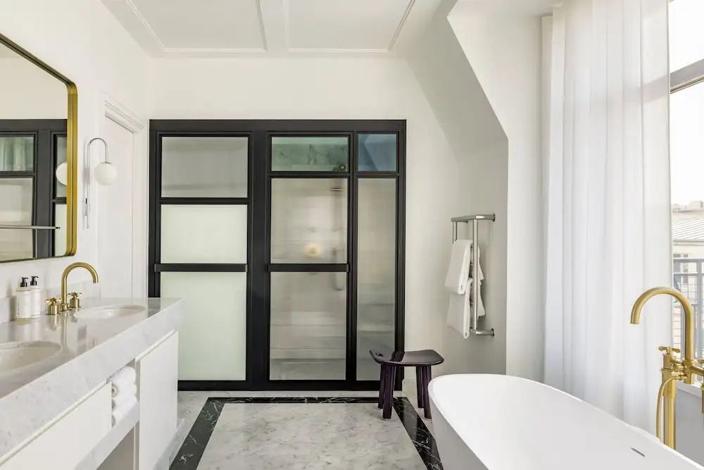 Elegantes Badezimmer mit Badewanne und großen Glasfenstern