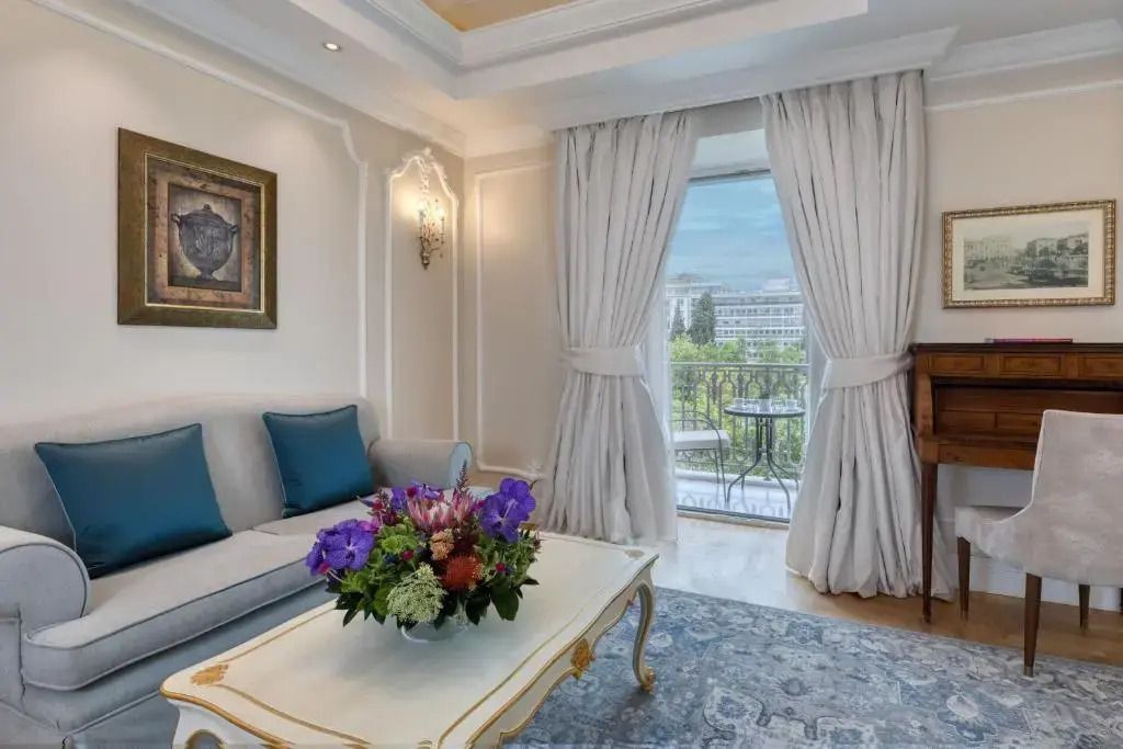 Wohnbereich mit Sofa und Zugang zum Stadtbalkon im Deluxe Zimmer