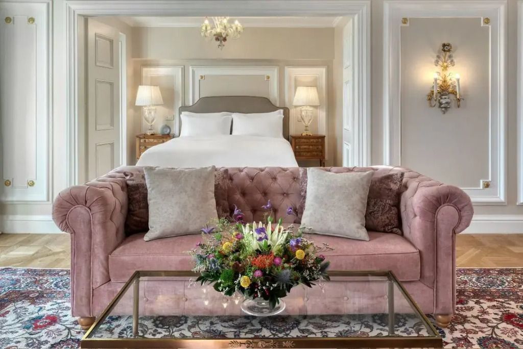 Luxuriöse Suite mit eleganter Couch und stilvollem Blumenarrangement