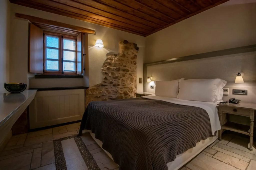 Gemütliches Doppelzimmer mit Steinwandakzent und Holzdecke