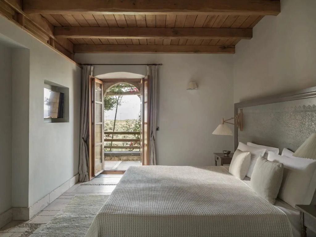 Elegantes Doppelbettzimmer mit Holzbalkendecke und Balkonblick auf Natur