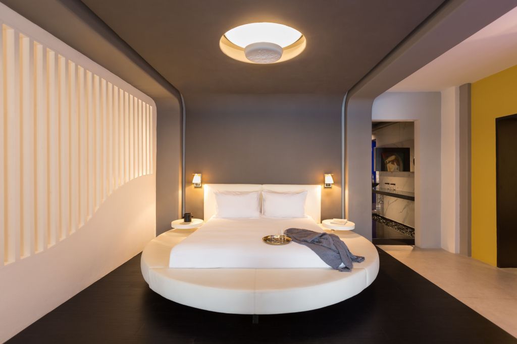 Elegantes modernes Schlafzimmer mit rundem Bett und stimmungsvoller Beleuchtung