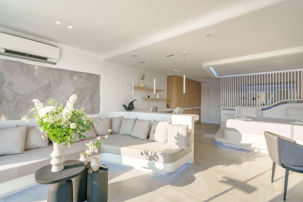 Geräumiges Wohnzimmer in der Luxus-Suite mit stilvollem Sofa und modernen Details.