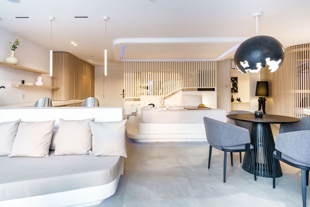 Offener Wohnbereich mit Bett und stilvoller Beleuchtung in der Suite.
