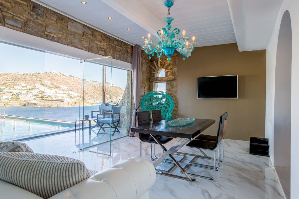 Elegantes Wohnzimmer mit Esstisch und Blick auf Meer und Terrasse