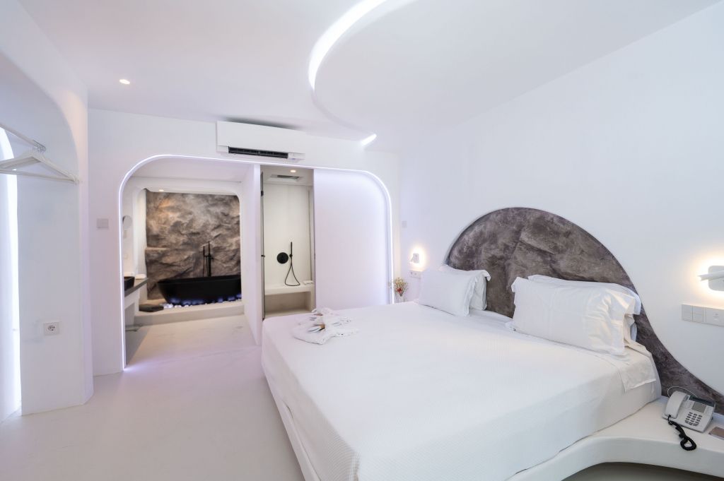 Modernes Schlafzimmer mit weißen Möbeln und luxuriösem Bad im Kivotos Mykonos Hotel