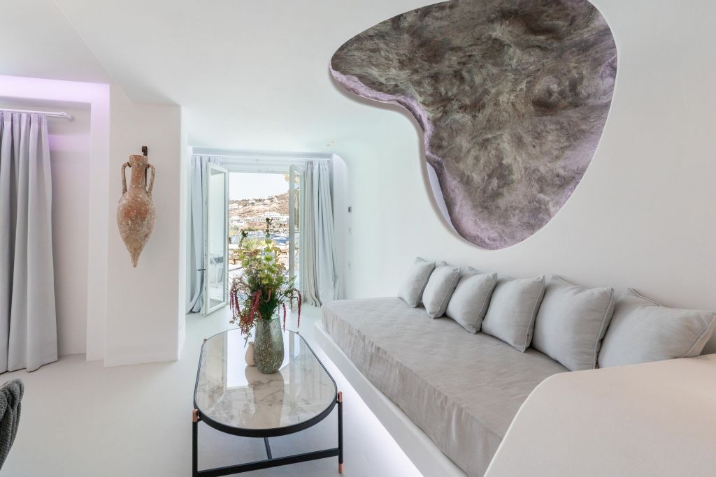 Helles Wohnzimmer in der Kivotos Mykonos Suite mit moderner Kunst an der Wand