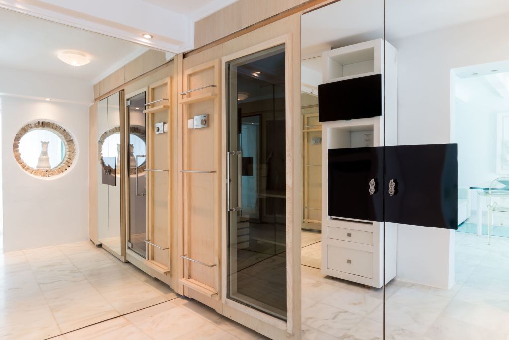 Flur mit Spiegelwand und eleganten Holztüren in moderner Suite.