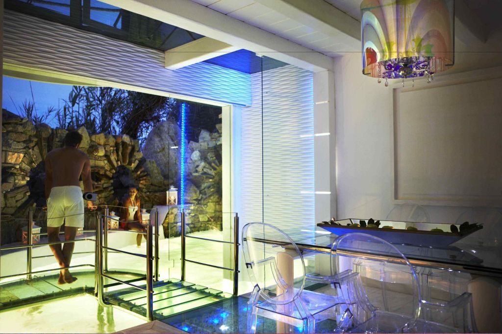 Stilvoller Innenbereich mit Glasdetails und Lichteffekten neben einem Pool.