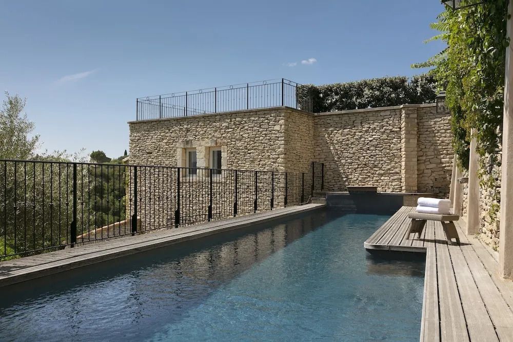 Privater Pool mit Steinmauer im Hotelgarten.