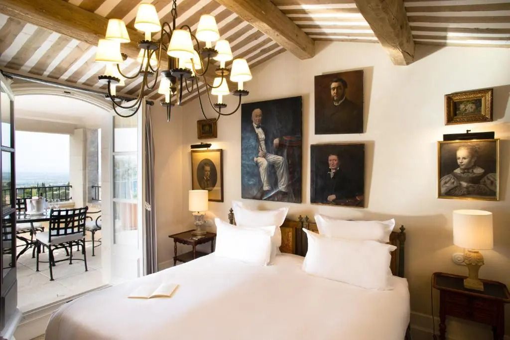 Luxuriöses Schlafzimmer in einer Suite mit Doppelbett und klassischen Porträts an der Wand