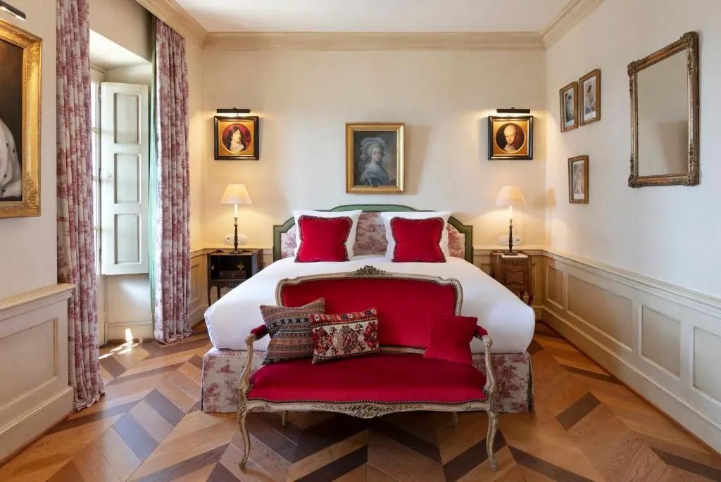 Luxuriöses Schlafzimmer mit klassischem Dekor und rotem Sofa