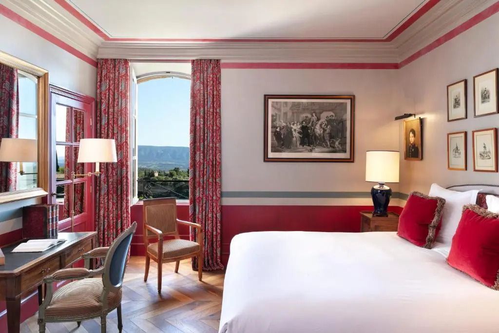 Helles Zimmer mit Doppelbett und Ausblick auf die Landschaft durch das Fenster