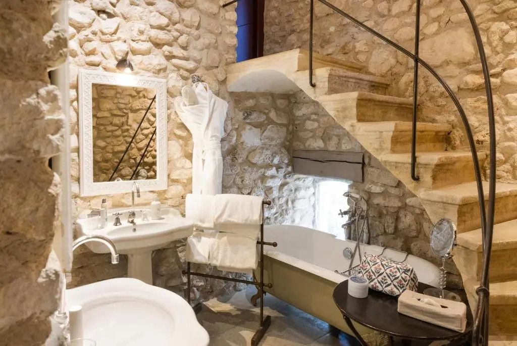 Luxuriöses Badezimmer mit freistehender Badewanne und Steinwand