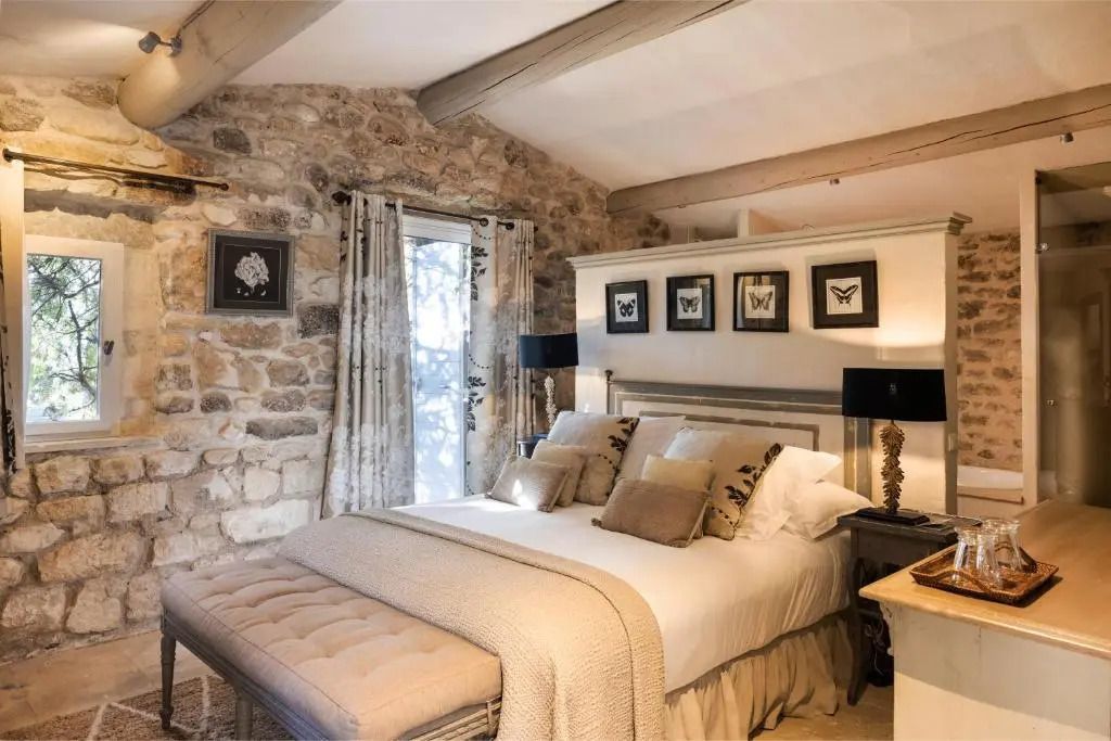 Schlafzimmer mit Steindetails und luxuriöser Bettwäsche