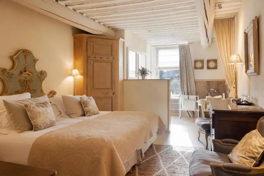 Helles Doppelzimmer mit Bett, Stehlampe und großen Fenstern