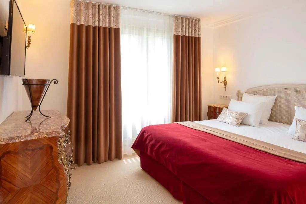 Kompaktes Schlafzimmer mit luxuriösen Details und Samtvorhängen.
