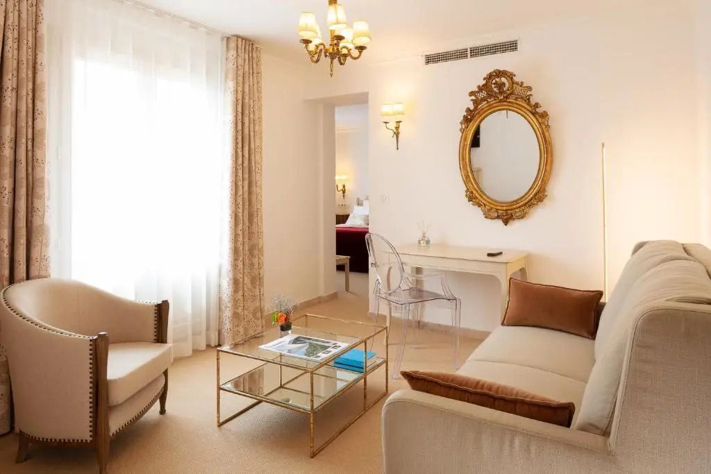Heller Salon mit prunkvollem Spiegel und eleganter Möblierung in der Suite.