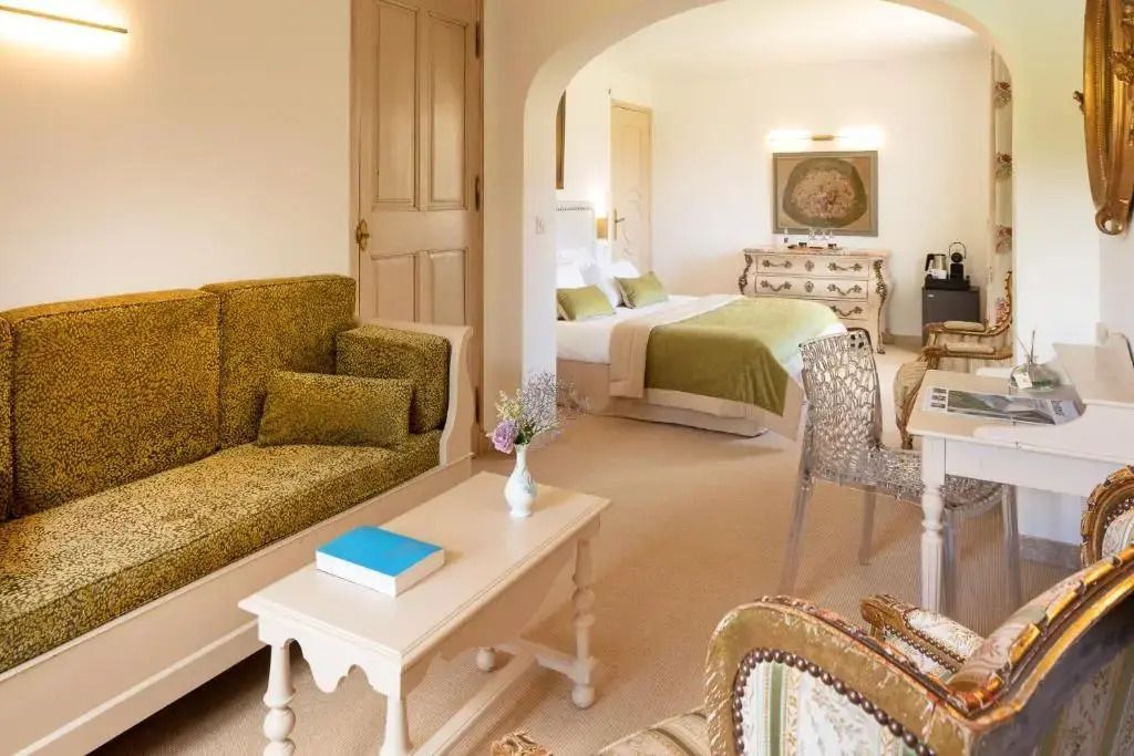 Gemütliche Junior-Suite mit Sitzecke. Doppelbett mit grünen Akzenten