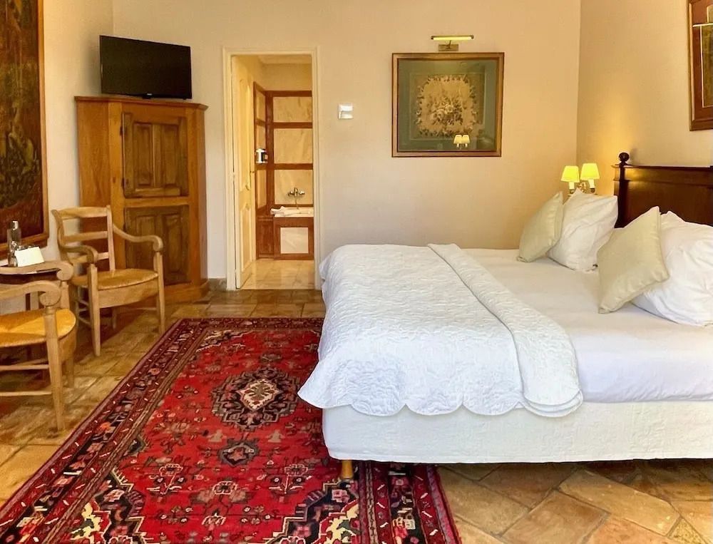 Klassisch eingerichtetes Doppelzimmer mit Teppich und Holzmöbeln